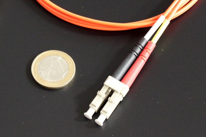 A duplex LC fibre connector beside a coin