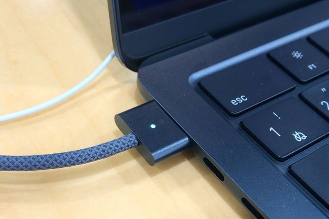 A MagSafe 3 plug attached to a MacBook Air