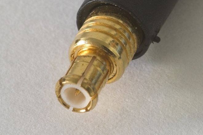 An MCX plug on a cable: a small gold slotted sleeve around a white insulator and a fine centre pin