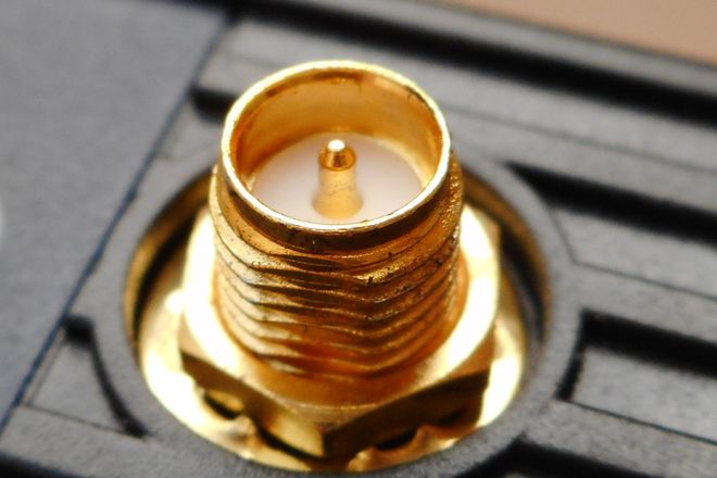 An RP-SMA socket on a Wi-Fi router: a gold threaded barrel with a centre pin