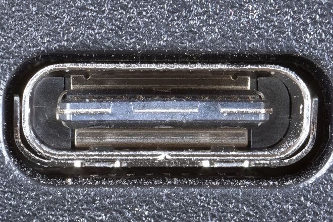 A USB-C port on a laptop, showing the central tongue