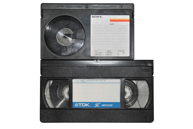 A Betamax cassette on top of a larger VHS cassette