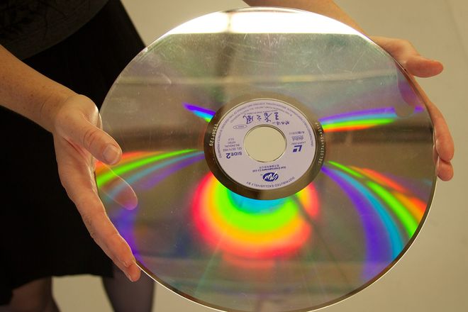 A LaserDisc held in two hands, the size of a vinyl LP