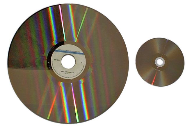 A LaserDisc beside a DVD, showing the difference in size
